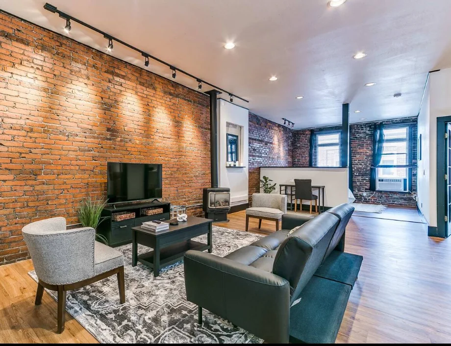 Stylish exposed-brick living room in a managed short-term rental — airbnb revenue management